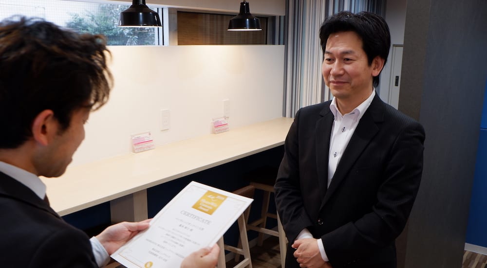 ShareWisアワード2018 エンカレッジオンライン大賞を受賞された藤本 剛士様が株式会社シェアウィズの高橋淳から賞状を受け取る様子の写真