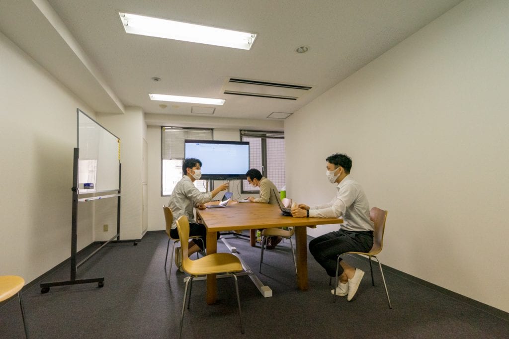 株式会社シェアウィズの大阪本社のミーティングスペースで会議している様子の写真