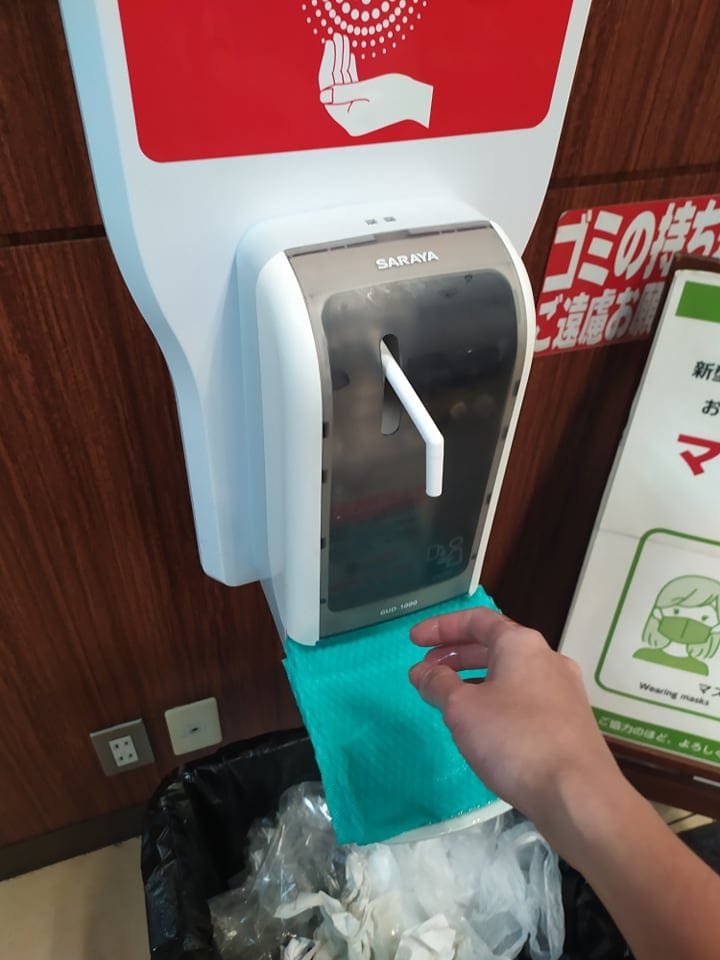 スーパーマーケットにあるアルコール消毒ディスペンサーの写真