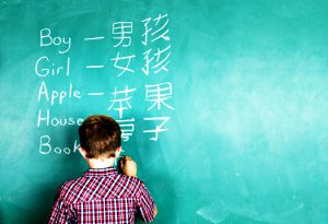 英語と中国語を書くバイリンガルの少年の画像