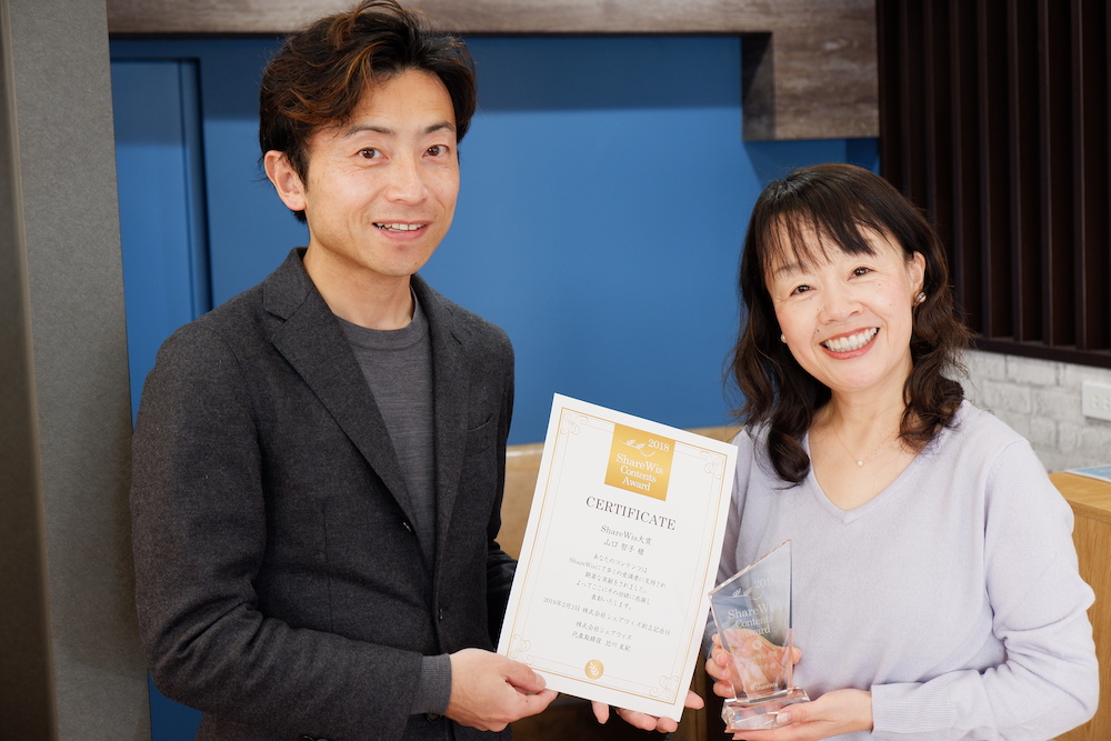 ShareWisアワード2018 ShareWis大賞の賞状とトロフィーをお持ちの山口智子様の写真